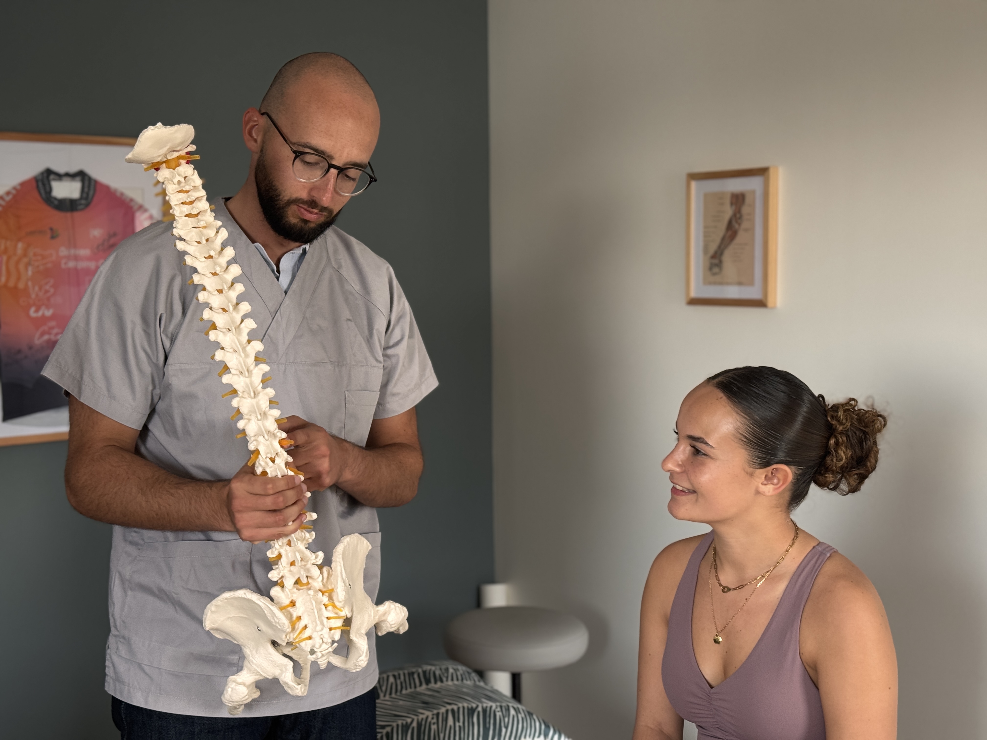 Vincent l'ostéopathe présente à sa patiente la structure d'une colonne vertébrale